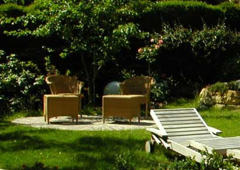 Eine kleine Terrasse in einem Wiener Garten: ein rund gepflastertes Platzerl unter einem Marillenbaum lädt zur Entspannung zwischen duftenden Rosen und Lavendel. Ein Fest für die Sinne.